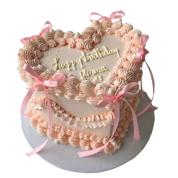 Decorative birthday cake with pink ribbons and 'Happy Birthday' text on a white background