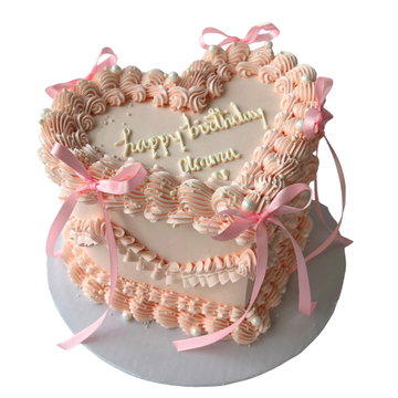 Decorative birthday cake with pink ribbons and 'Happy Birthday' text on a white background